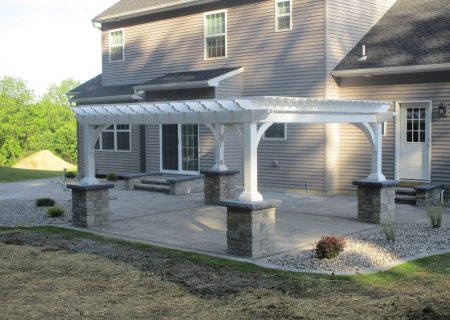 White vinyl pergola set on stone pillars.